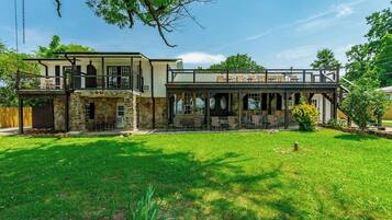 A two-story house with a patio area and a stone facade.