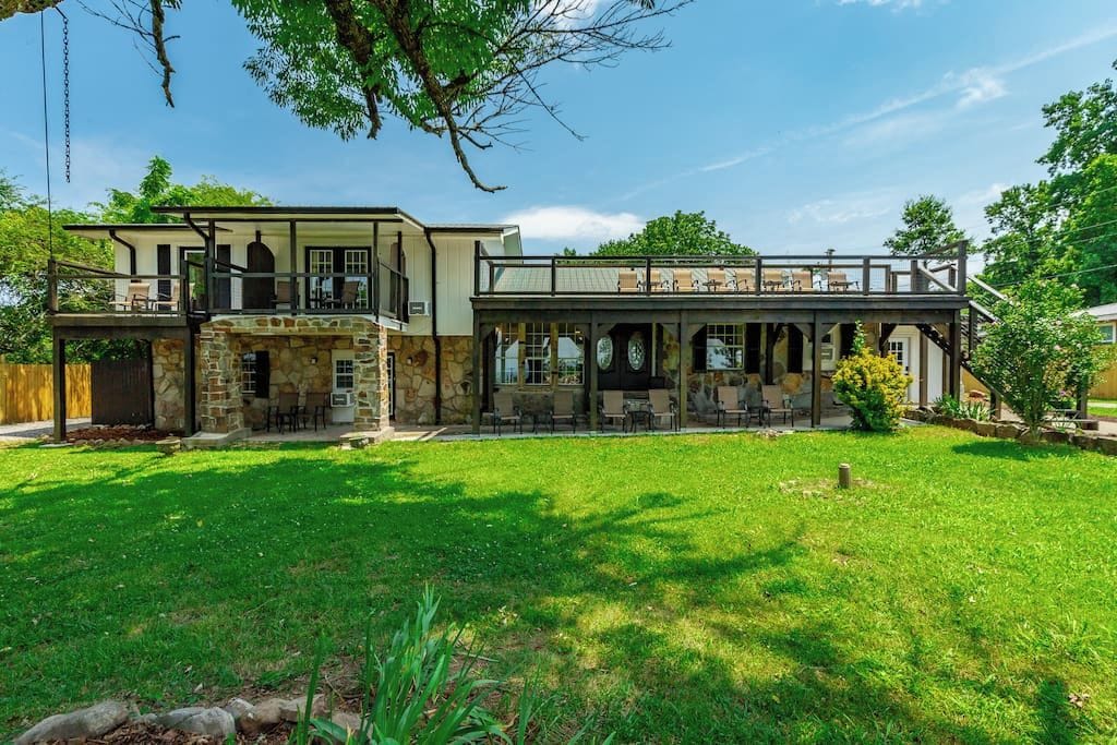 A two-story house with a patio area and a stone facade.