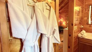 A wooden interior with a sign reading 'TOWELS' above a rack of white robes.