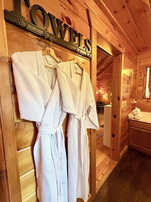 Un intérieur en bois, avec une enseigne indiquant « SERVIETTES » au-dessus d’un portant où sont disposées des robes blanches.