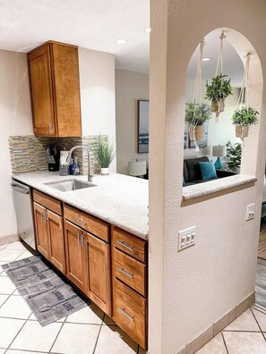 A kitchen with wooden cabinets, a granite countertop, and a built-in sink.