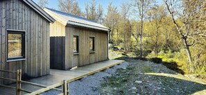A wooden cabin with a sloped roof, a wooden deck, and a gravel path leading to it. - Mountain cabin with beautiful views at 1000m (Ål)