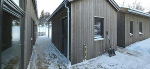 A wooden building with a metal door and window, a metal pipe, and a shovel on the ground. - Mountain cabin with beautiful views at 1000m (Ål)