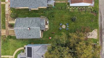 A residential area with multiple houses, a paved driveway, and a grassy lawn.