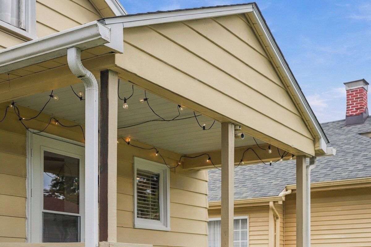 A house with a porch, a chimney, and string lights.
