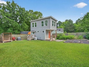 A two-story house with a fenced backyard, a covered porch, and a small deck. - Stay Next 2 Duke Hospital, Fire Pit & King Bed (Durham)