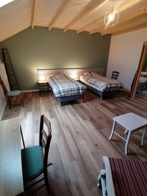 A room with two beds, a chair, a small table, and a ladder. - Gîte du Bois de Reine (Frébuans)