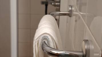 A bathroom with a towel rack holding a white towel.