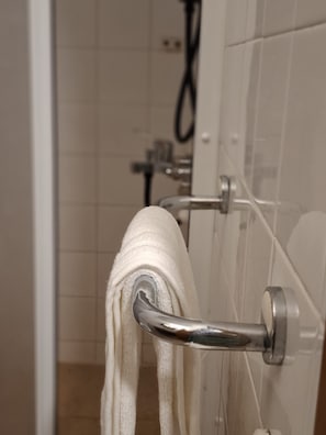 A bathroom with a towel rack holding a white towel.