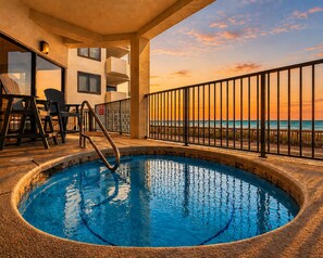 A pool area with a view of the ocean, a set of stairs leading to a balcony, and a seating area with chairs. - "Broadmoor #705" --- New! Beachfront 3BR, Stunning Gulf Views, Pool, Hot Tub (Orange Beach)