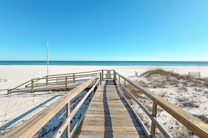 A wooden boardwalk leading to a beach with clear skies. - "Broadmoor #705" --- New! Beachfront 3BR, Stunning Gulf Views, Pool, Hot Tub (Orange Beach)