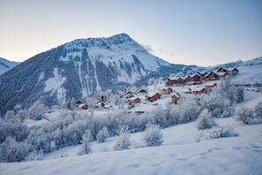 A snow-covered mountain with a cluster of wooden chalets.
