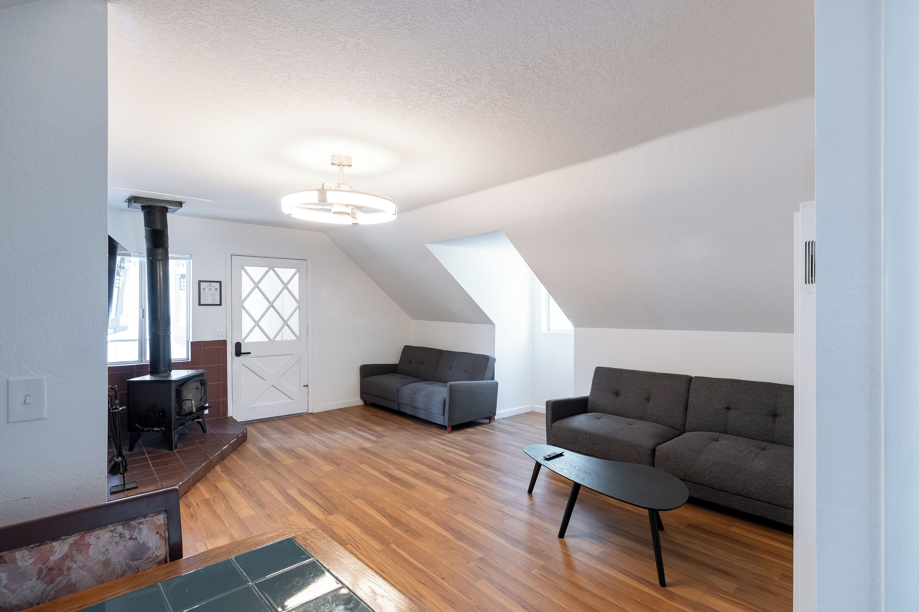 Un ampio loft con soffitto alto, camino a incasso e un'accogliente area salotto con divano e poltrone.