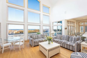Mid Level: Spacious living area with a two-story window wall, panoramic ocean views, ample seating, flat-screen smart TV and direct access to the sun deck. - Pine Island Oceanfront Private Pool, Beach Access! (Corolla)