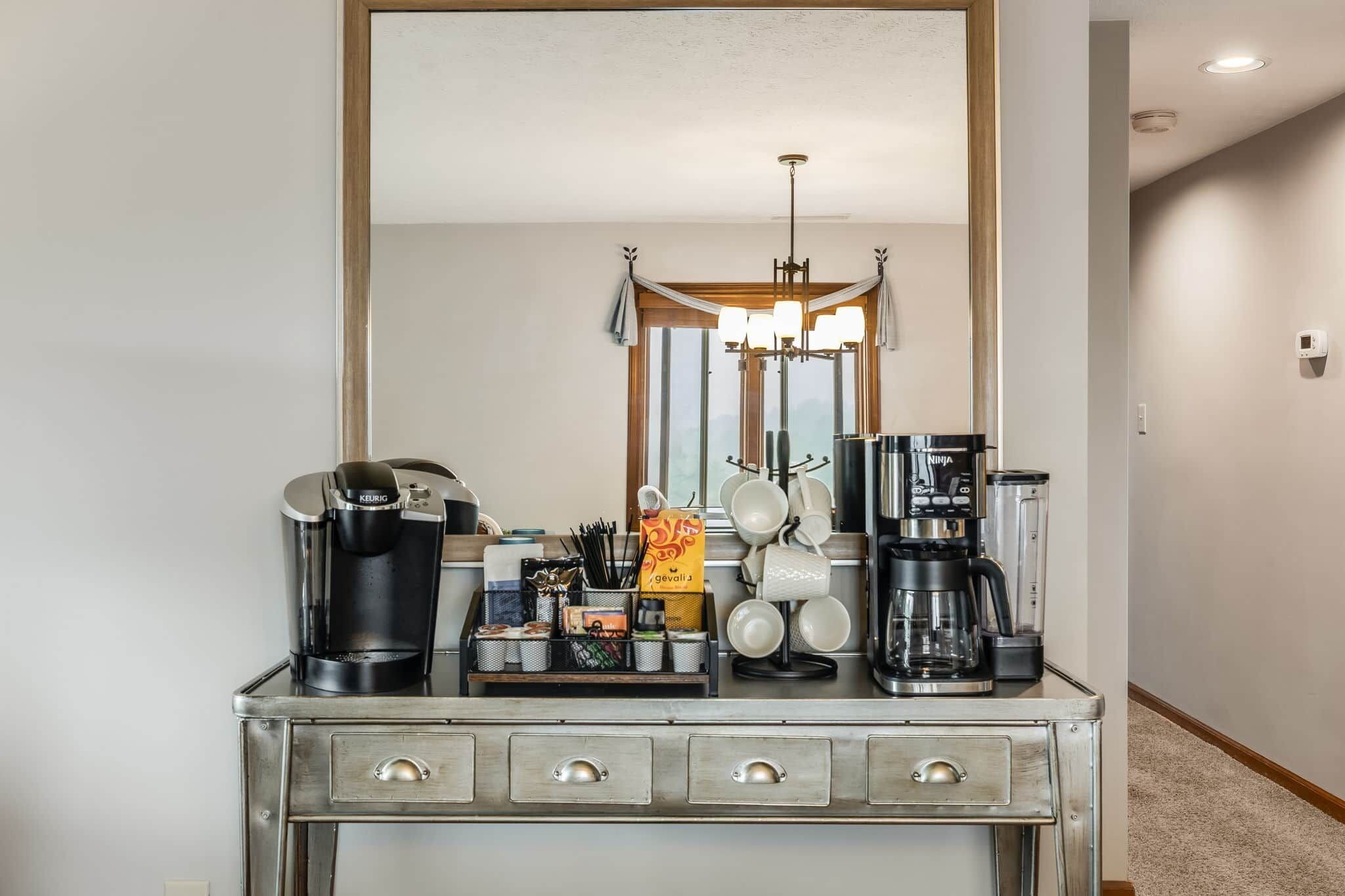 Una kitchenette equipada con cafetera, licuadora y hervidor.