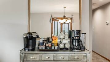 Una kitchenette equipada con cafetera, licuadora y hervidor.