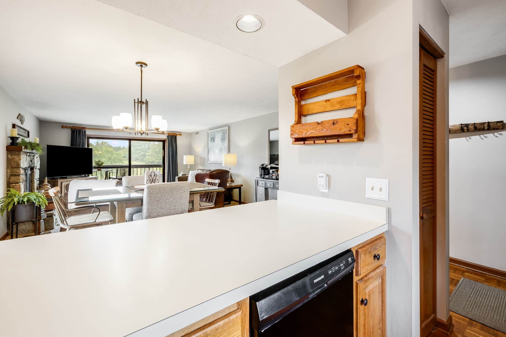 Una cocina moderna con una isla grande, armarios de madera y lavavajillas integrado.