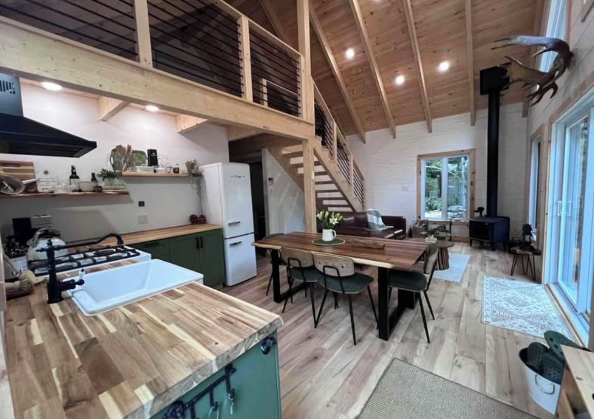 A spacious kitchen with a wooden countertop and a dining area with a table and chairs.
