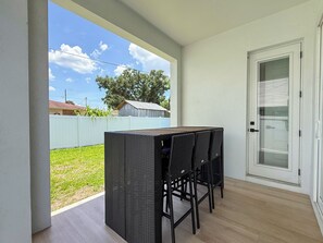 A balcony with a table and chairs, a view of the sky, and a door with a window. - Walk to Raymond James Stadium 3 Bedroom West Tampa Midtown Luxury Home (Tampa)