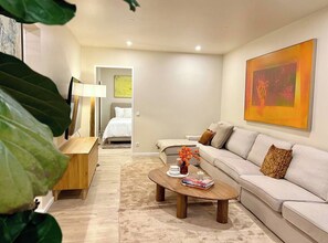 A modern living room with a sofa, coffee table, and a painting on the wall. - ALEXA Spacious Design Apart up to 10 Pax/Parking (Berlin)