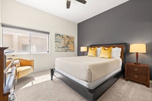A hotel room with a bed, bedside tables, a desk, and a window. - Private Pool & Firepit Escape in Mission Hills Country Club | Mountain Views, Golf & Pickleball (Rancho Mirage)