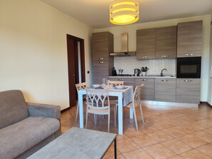 Eine moderne Küche mit Essbereich, einer Couch und einem Tisch für zwei Personen.