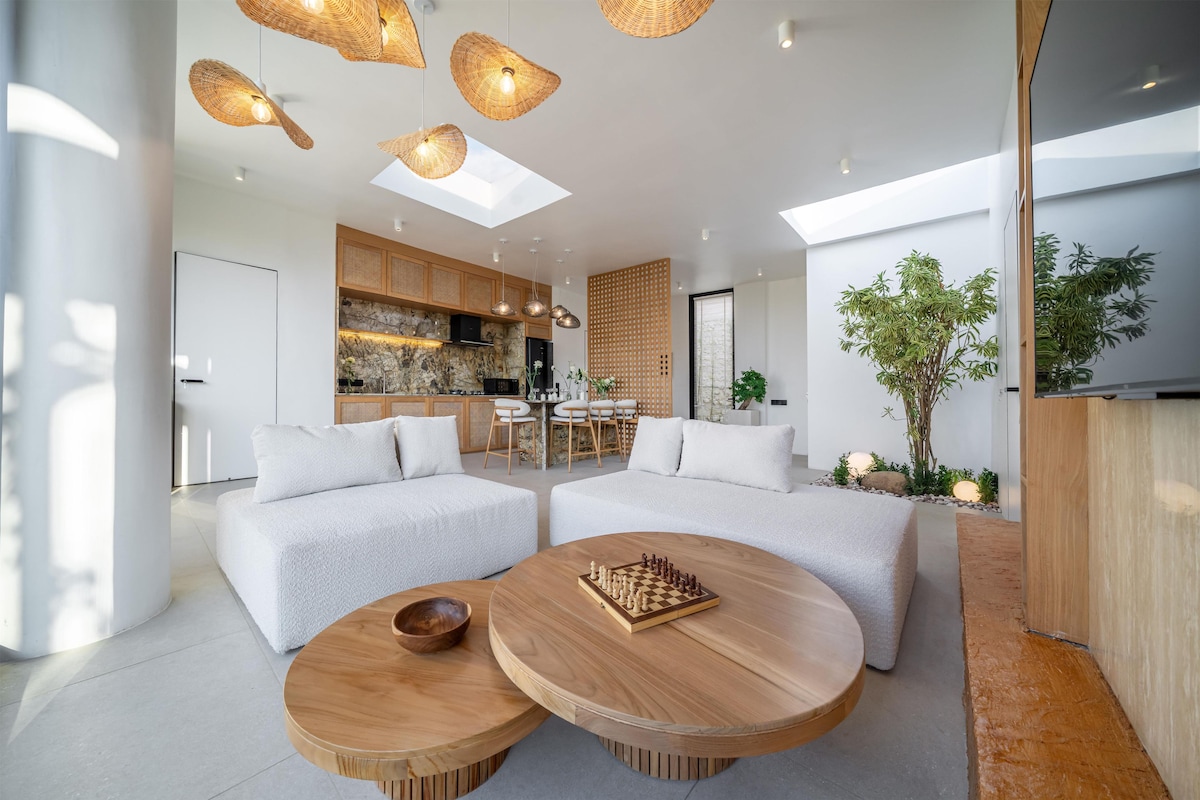 Uma sala de estar moderna com um conjunto de sofás, uma mesa de centro e um tabuleiro de xadrez.