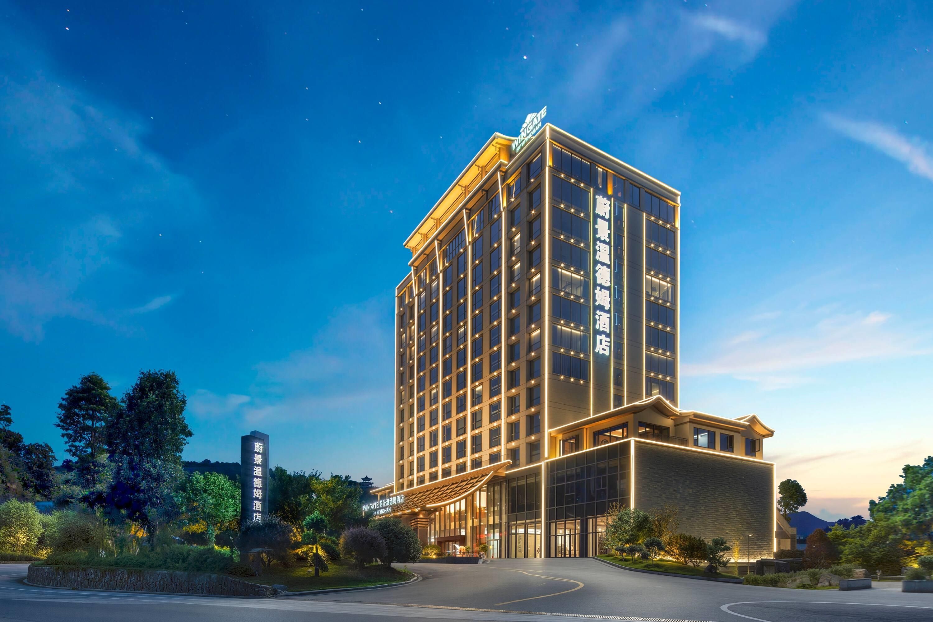 Un edificio hotel di diverse altezze dal design moderno, con un ingresso e una segnaletica ben visibili.