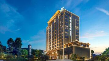 Un edificio hotel di diverse altezze dal design moderno, con un ingresso e una segnaletica ben visibili.