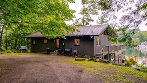 Eine Hütte mit Terrasse und Steg an einem See.