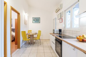 Una cocina compacta con comedor, lavavajillas y ventana con vistas.