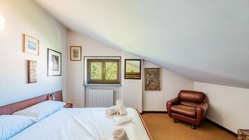 Une chambre d’hôtel avec un lit, une chaise et des œuvres d’art accrochées aux murs.