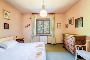 A bedroom with a bed, dresser, and window with curtains. - Il rifugio del viaggiatore antico (Santa Croce)