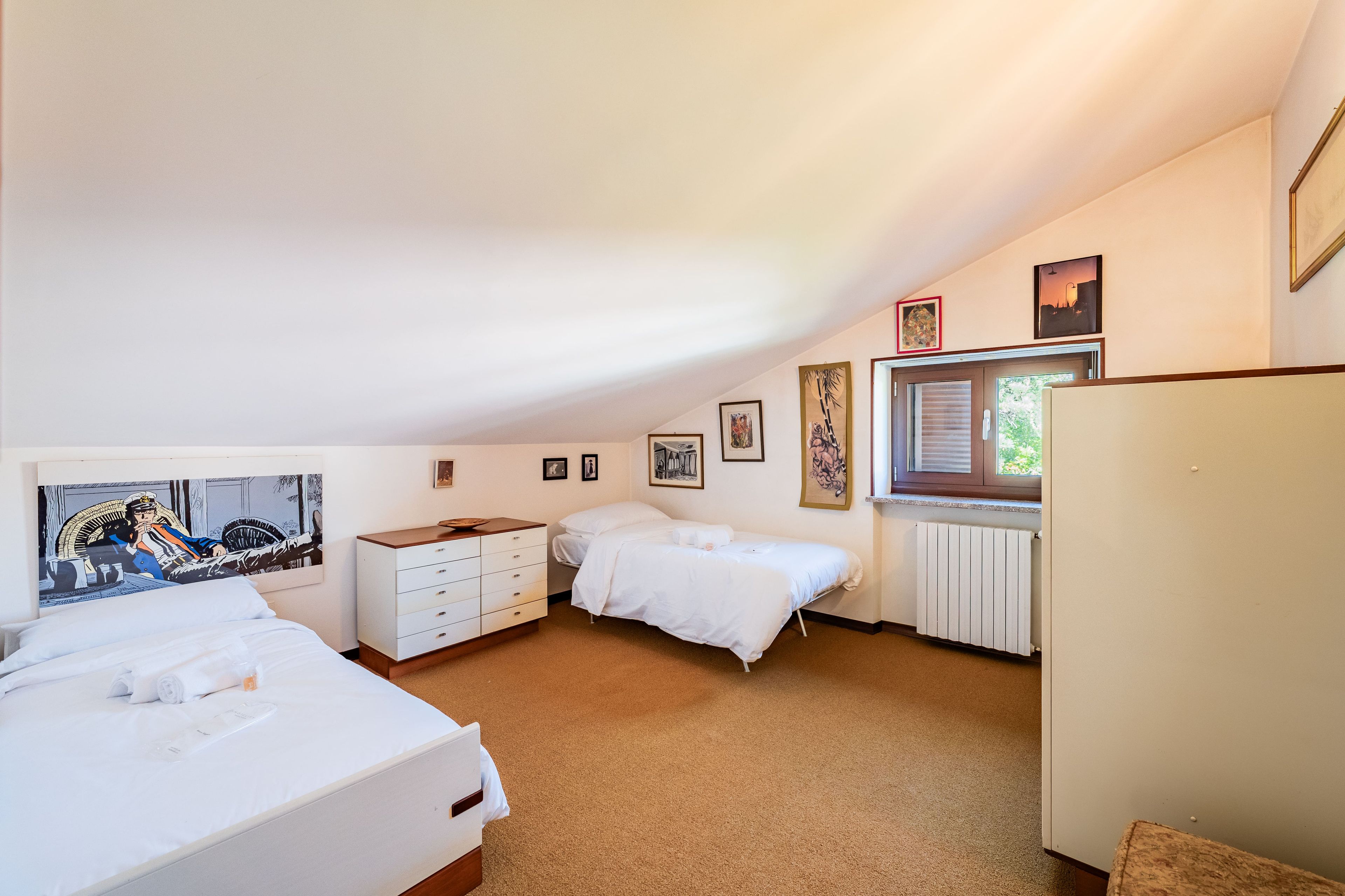 Un dormitorio con dos camas, un aparador y un radiador.
