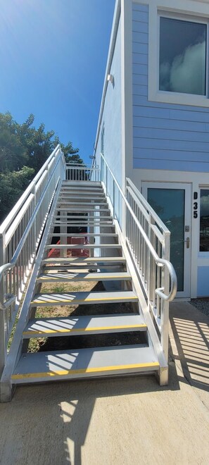 A set of outdoor stairs leading to a building entrance with a number '035' on the door. - Crystal Cove at Sapphire Beach – Sunrise Views & Steps to Paradise (St Thomas)