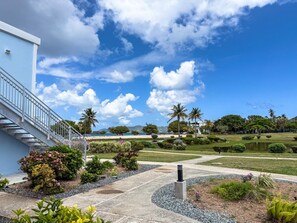 A landscaped garden with a pathway leading to a building with a staircase. - Sapphire Beachfront Condo w/ Pool, 2 Baths (St. Thomas)