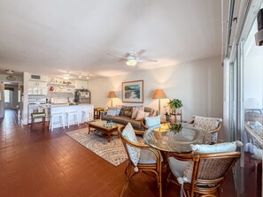A spacious living area with a dining table, chairs, a sofa, and a kitchen in the background. - Sapphire Beachfront Condo w/ Pool, 2 Baths (St. Thomas)