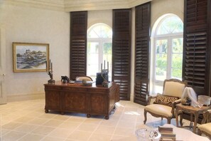 A spacious room with a large wooden desk, a comfortable armchair, and a painting on the wall. - An Elite Traveller`s Top 10 Caribbean Villa (St. Croix)