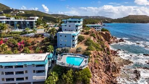 A coastal hotel with multiple buildings, a swimming pool, and a view of the ocean. - Budget friendly 2br condo - walk to the beach! (St. Thomas)
