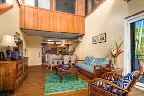 A spacious living area with a dining table, wicker furniture, and a view of the kitchen. - Budget friendly 2br condo - walk to the beach! (St. Thomas)