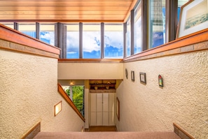 A staircase with a view to the outside, a door, and a small shelf with decorative items. - Budget friendly 2br condo - walk to the beach! (St. Thomas)
