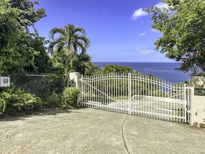 A gated entrance to a property with a view of the ocean. - Serene Luxury at Whale Watch – Your Island Oasis (St. Thomas)