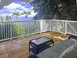 A covered patio with a white railing, a glass-top table, and a cushioned sofa. - 4BR Waterfront - 5 Minutes To Magen`s (St. Thomas)