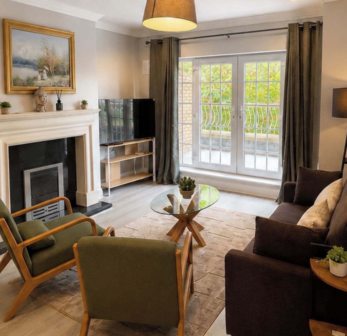 A living room with a fireplace, a television, a glass coffee table, and a sofa.