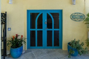 A turquoise door with a 'WELCOME' sign above it, flanked by potted plants. - 4BR - centrally located & mins. from Magen`s Bay! (St. Thomas)
