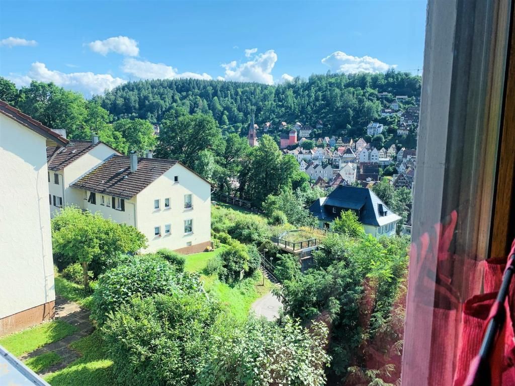 Ein Wohngebiet mit Häusern, einer Kirche und einer Hügelkette im Hintergrund.
