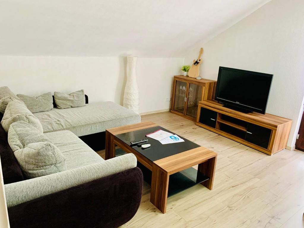 Ein modernes Wohnzimmer mit einer Couch, einem Couchtisch, einem Fernseher und einem Schrank.