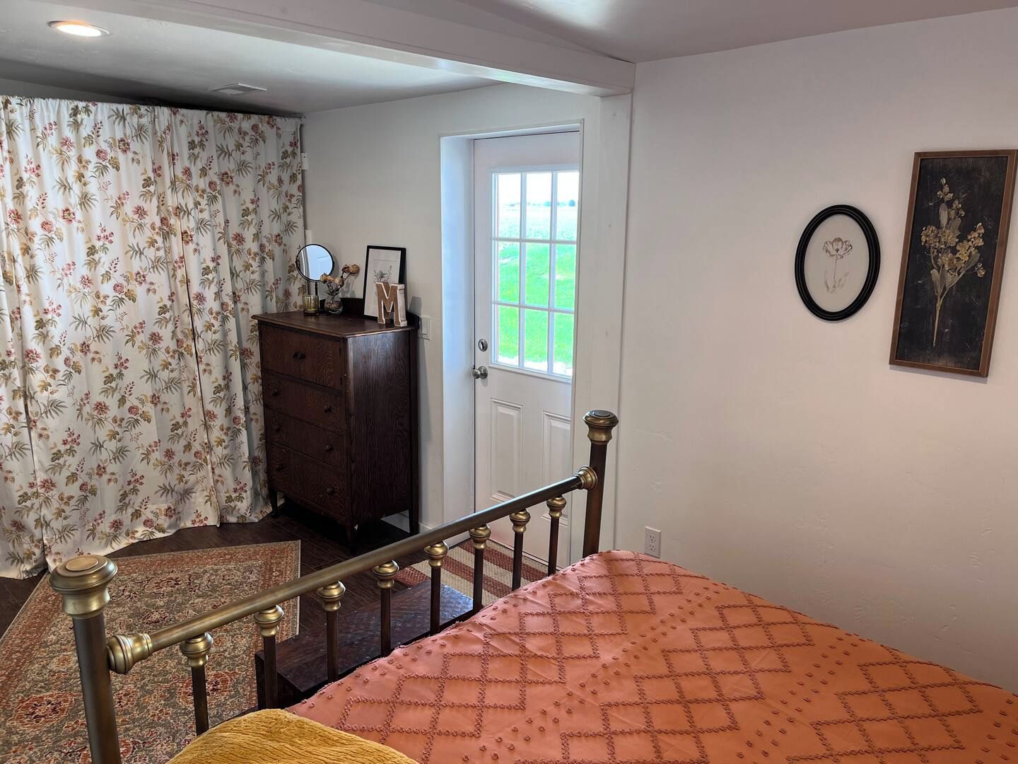 Ein Schlafzimmer mit einem Bett, einem Schminktisch, einem Spiegel und einer Tür, die auf einen Balkon führt.