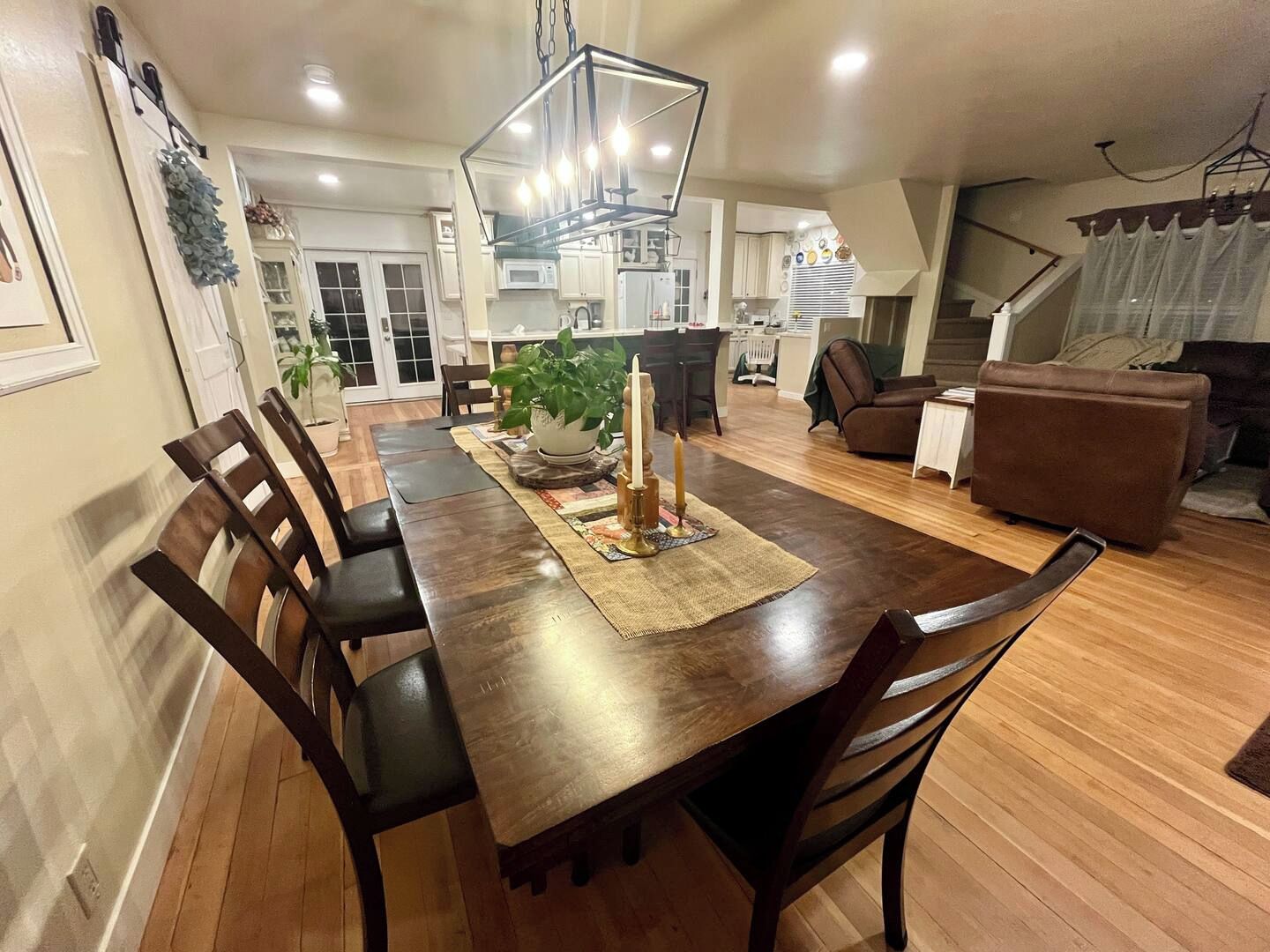 Uma sala de jantar ampla, com uma longa mesa de madeira, várias cadeiras e um objeto decorativo central.