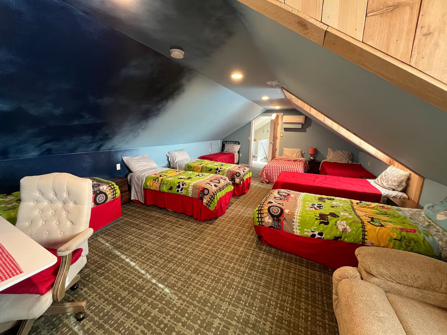 Une chambre avec quatre lits, un bureau et une chaise.